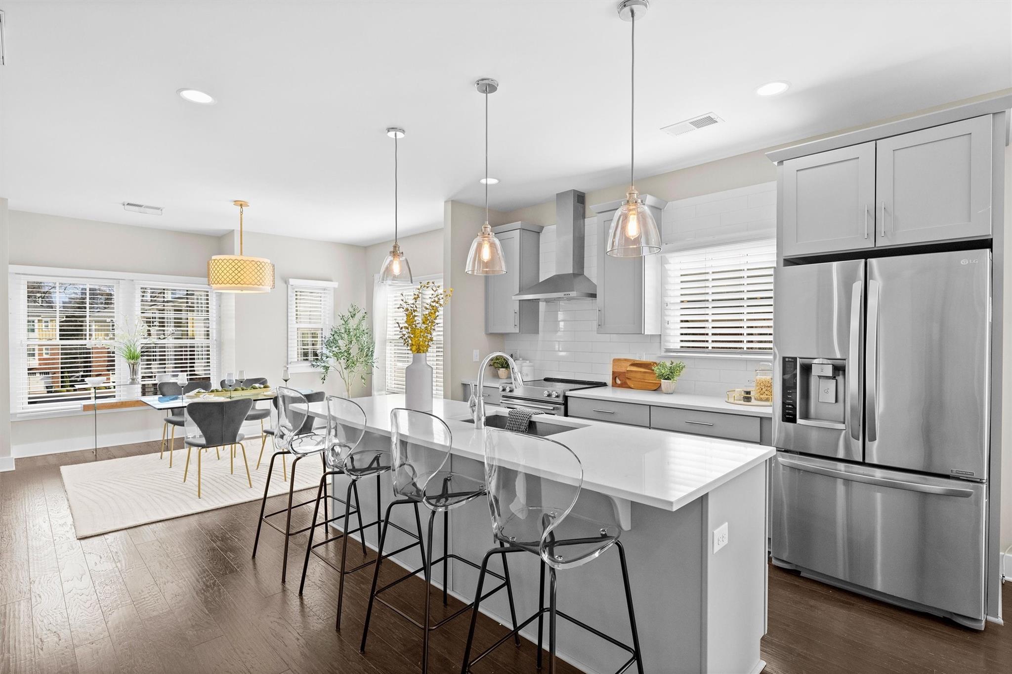 131 Grandin Road Charlotte, NC 28208 - Photo 19 of 45 a kitchen with stainless steel appliances a dining table chairs a sink and white cabinets