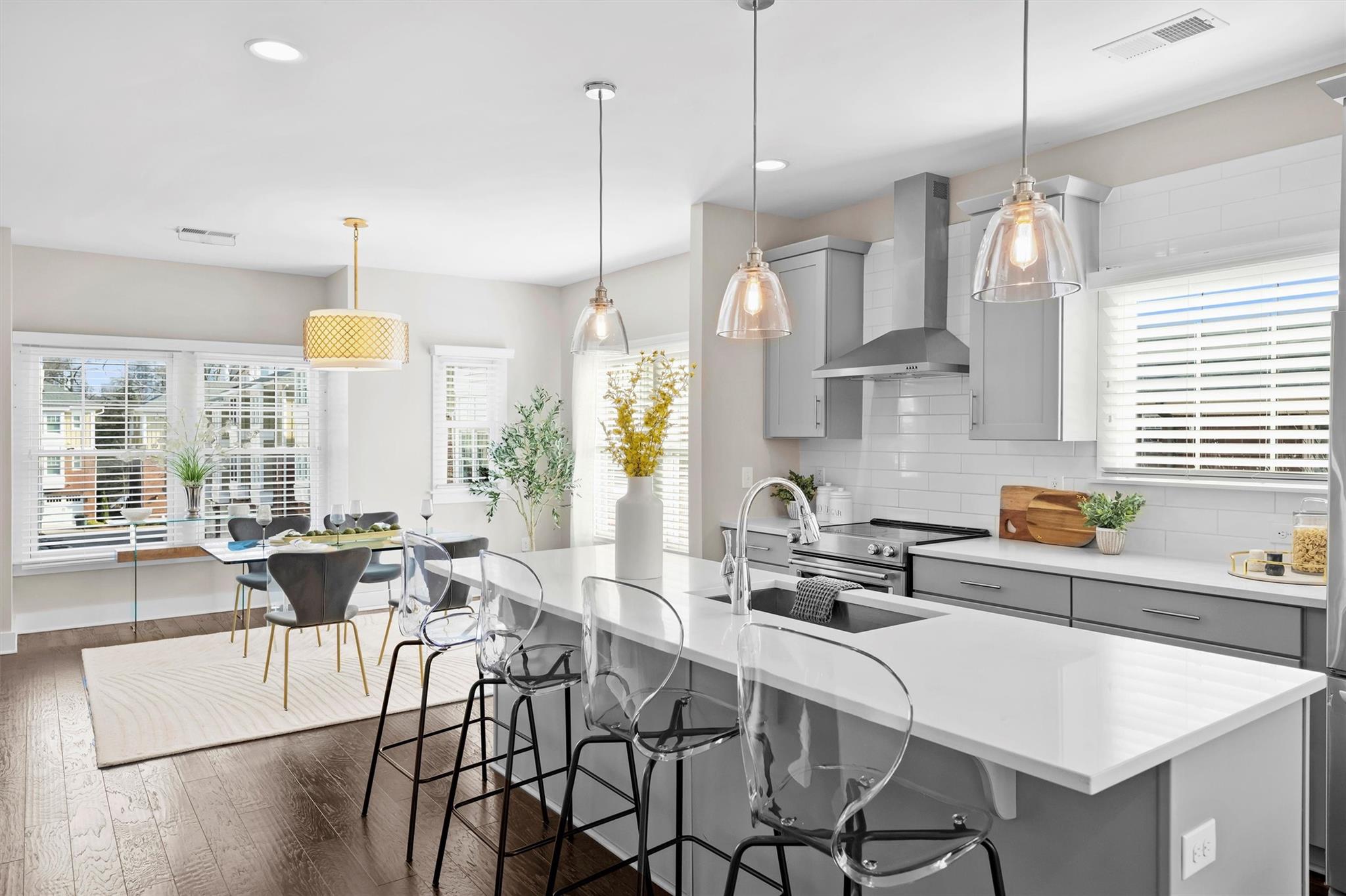 131 Grandin Road Charlotte, NC 28208 - Photo 20 of 45 a kitchen with stainless steel appliances a dining table chairs sink and white cabinets