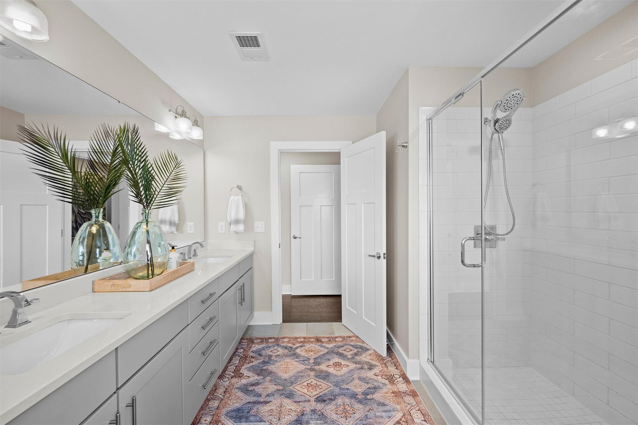 131 Grandin Road Charlotte, NC 28208 - Photo 35 of 45 a bathroom with a double vanity sink a large mirror a shower and a bathtub
