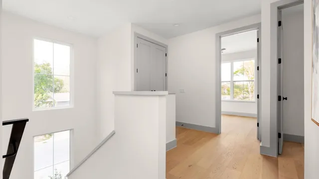 a view of hallway with wooden floor and window