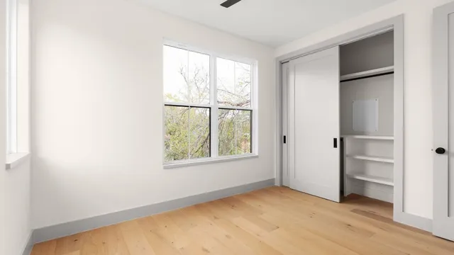 an empty room with windows and closet