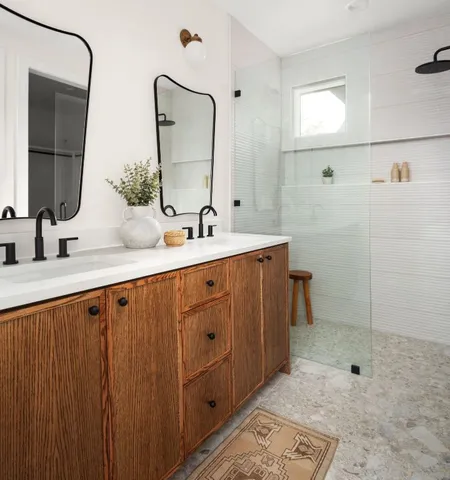 a bathroom with a double vanity sink mirror and shower