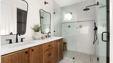 a bathroom with a double vanity sink a toilet and shower