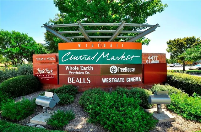 a sign that is sitting on a wooden bench in a park