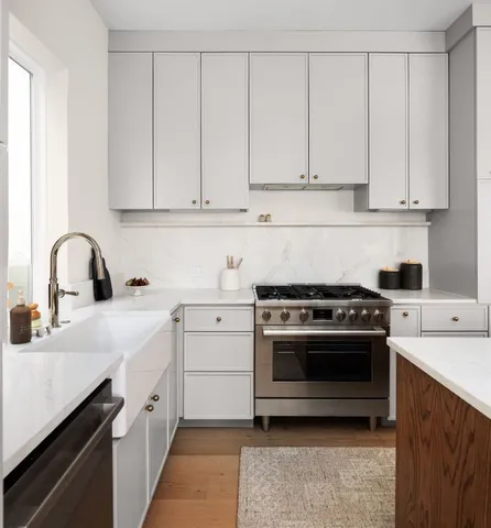a kitchen with white cabinets and a stove top oven