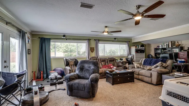 a living room with furniture ceiling fan and a window