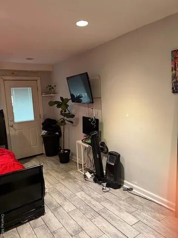 a living room with furniture a flat screen tv and gym equipment