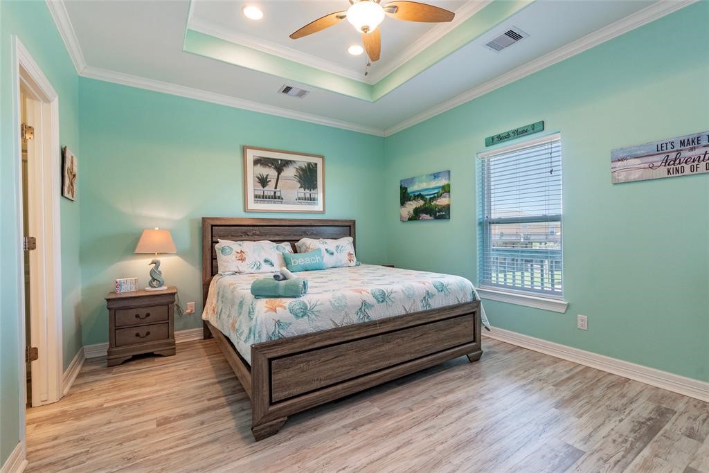 987 Surf Crystal Beach Crystal Beach, TX 77650 - Photo 18 of 45 a bedroom with a bed wooden floor and window