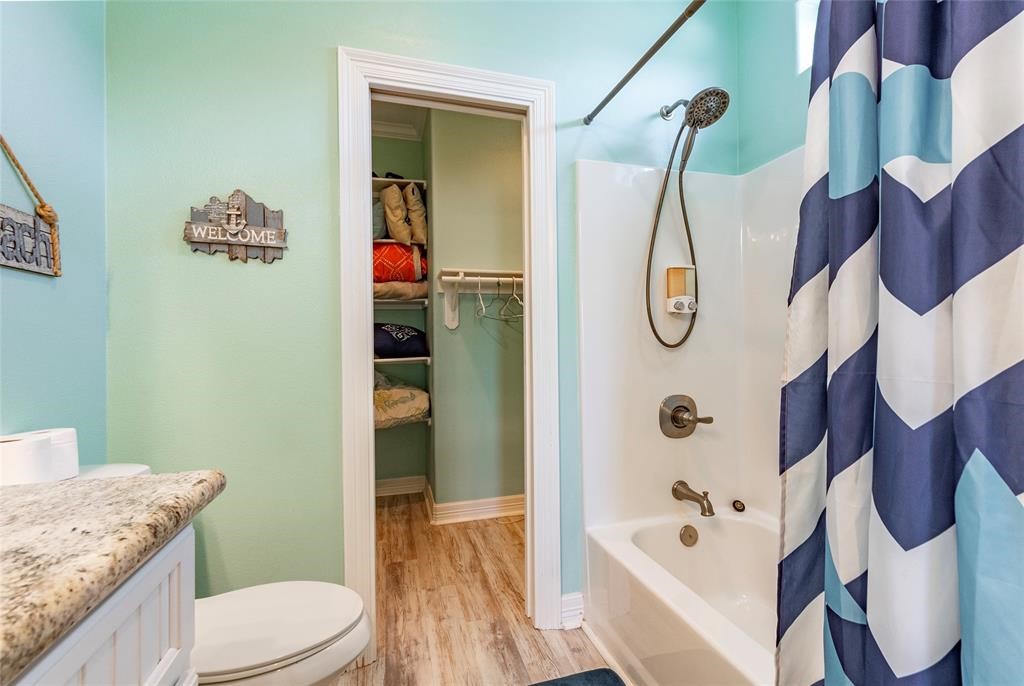 987 Surf Crystal Beach Crystal Beach, TX 77650 - Photo 21 of 45 a bathroom with a granite countertop toilet sink and mirror