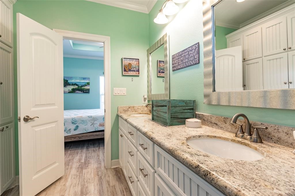 987 Surf Crystal Beach Crystal Beach, TX 77650 - Photo 22 of 45 a en suite bathroom with a granite countertop sink and a mirror