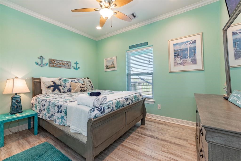 987 Surf Crystal Beach Crystal Beach, TX 77650 - Photo 23 of 45 a bedroom with a bed and a chandelier