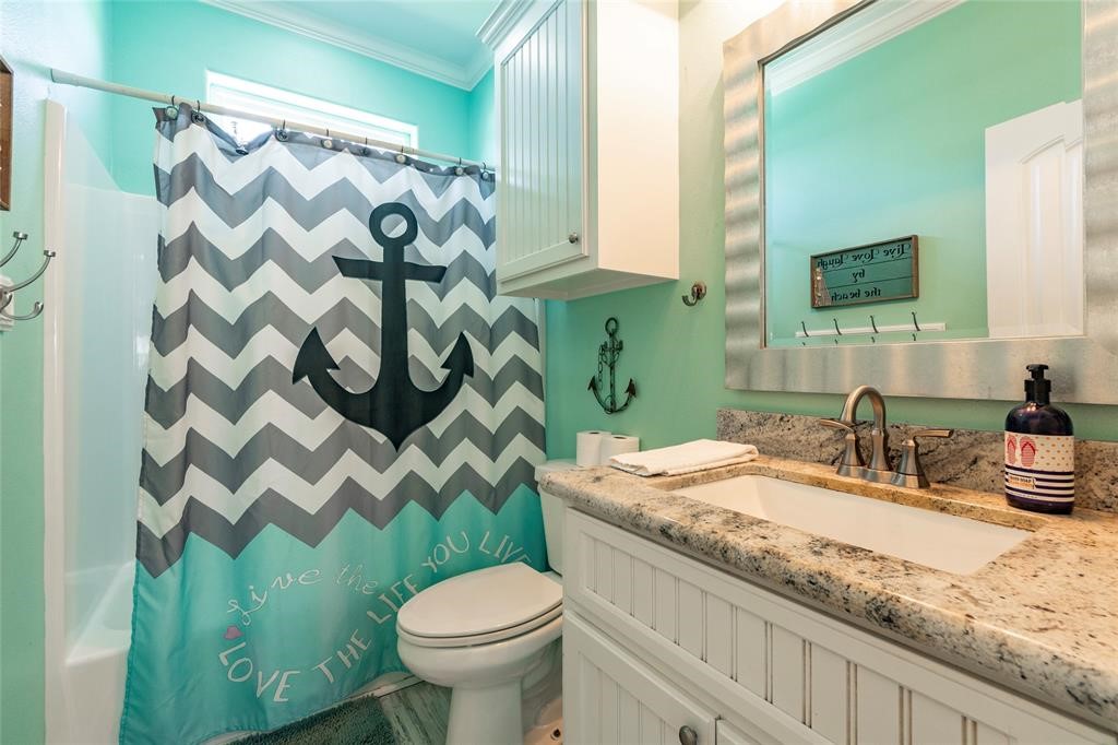 987 Surf Crystal Beach Crystal Beach, TX 77650 - Photo 24 of 45 a bathroom with a granite countertop sink and a mirror