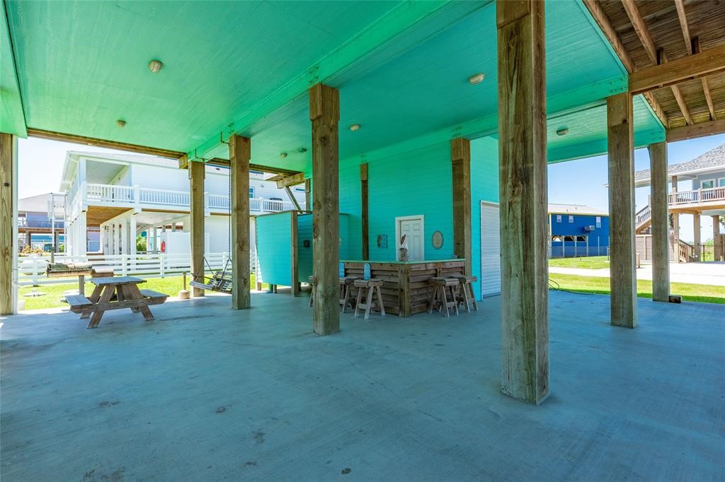 987 Surf Crystal Beach Crystal Beach, TX 77650 - Photo 34 of 45 a view of a swimming pool with a lounge chair and floor to ceiling window