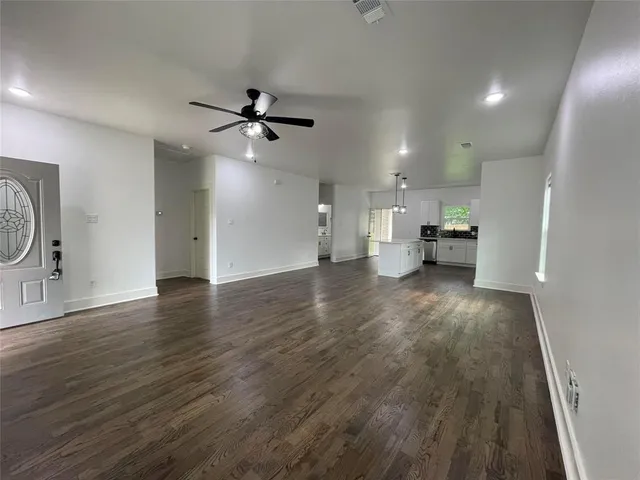 a view of a kitchen with wooden floor and a ceiling fan