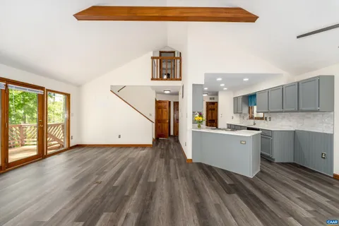 a view of a kitchen with wooden floor and electronic appliances
