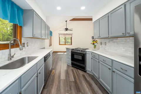 a kitchen with granite countertop a sink stainless steel appliances and cabinets