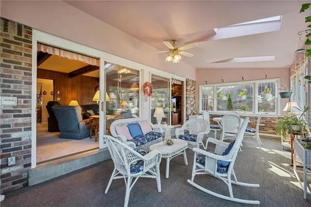a dining room with furniture a large window and chandelier