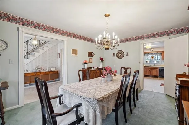 a view of a dining room with furniture a chandelier and wooden floor