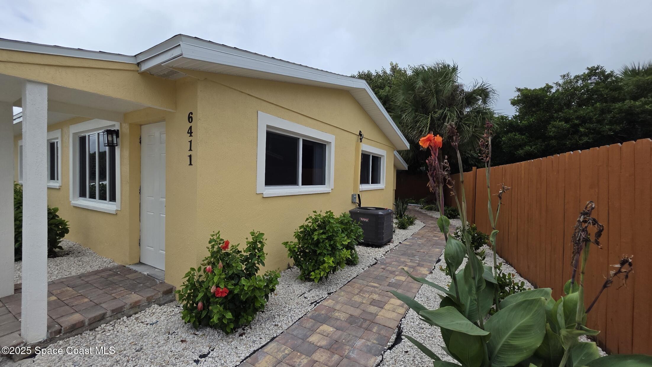 6411 Ridgewood Avenue Cocoa Beach, FL 32931 - Photo 11 of 15 a front view of a house with a yard