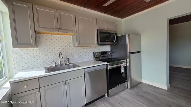 a kitchen with stainless steel appliances granite countertop a sink a stove a microwave and cabinets