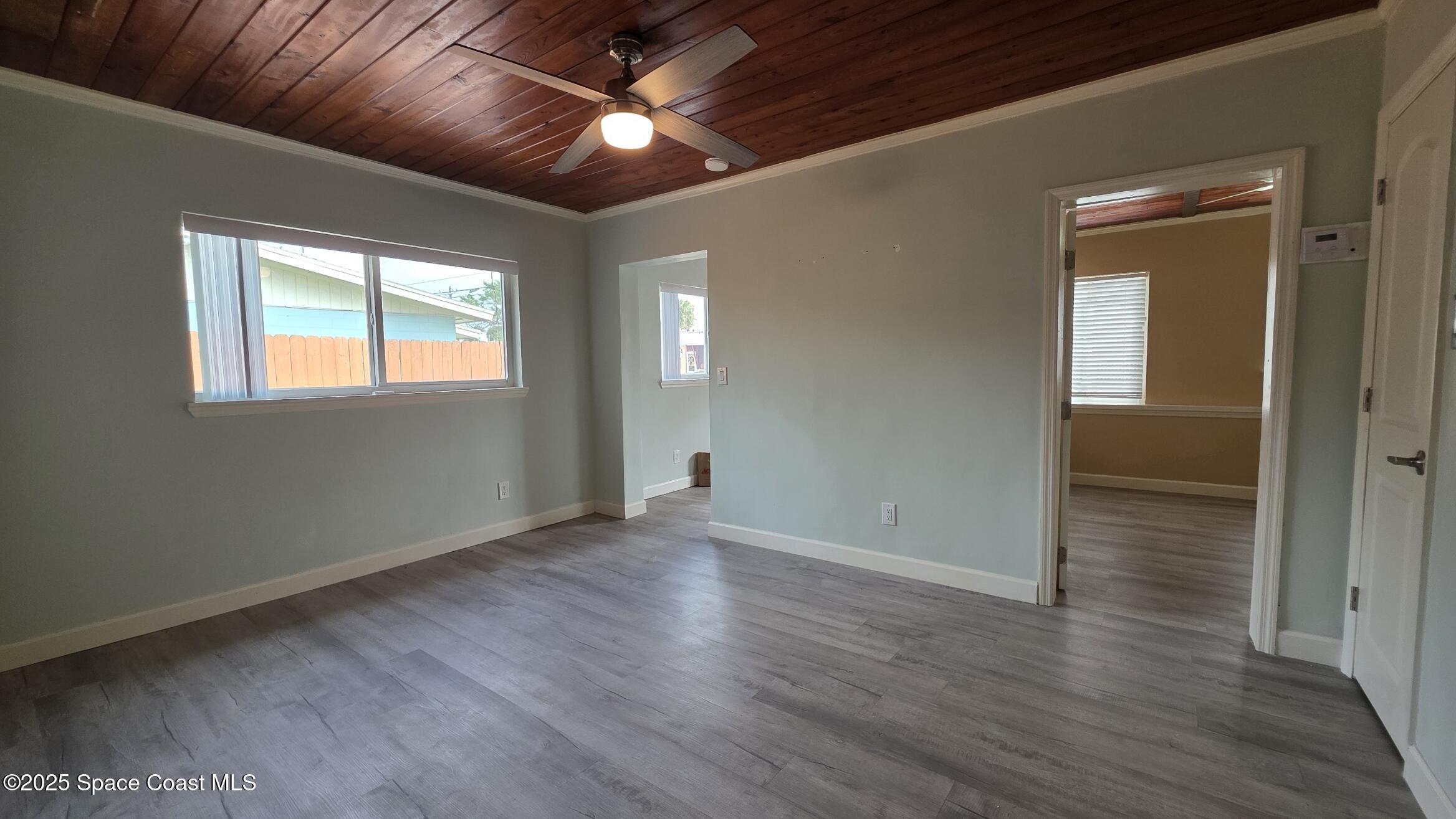 6411 Ridgewood Avenue Cocoa Beach, FL 32931 - Photo 4 of 15 an empty room with wooden floor and windows