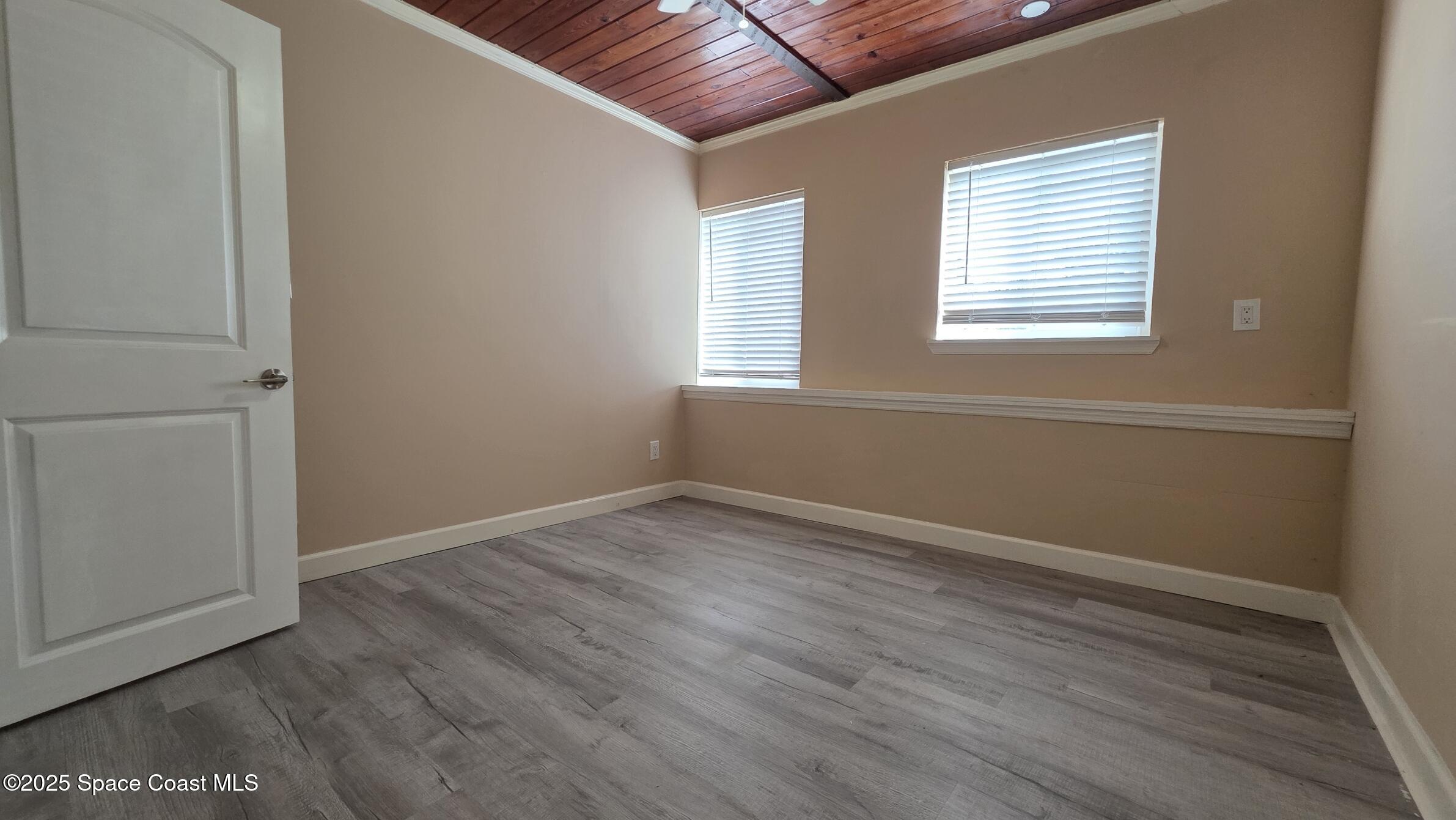 6411 Ridgewood Avenue Cocoa Beach, FL 32931 - Photo 6 of 15 an empty room with wooden floor and windows