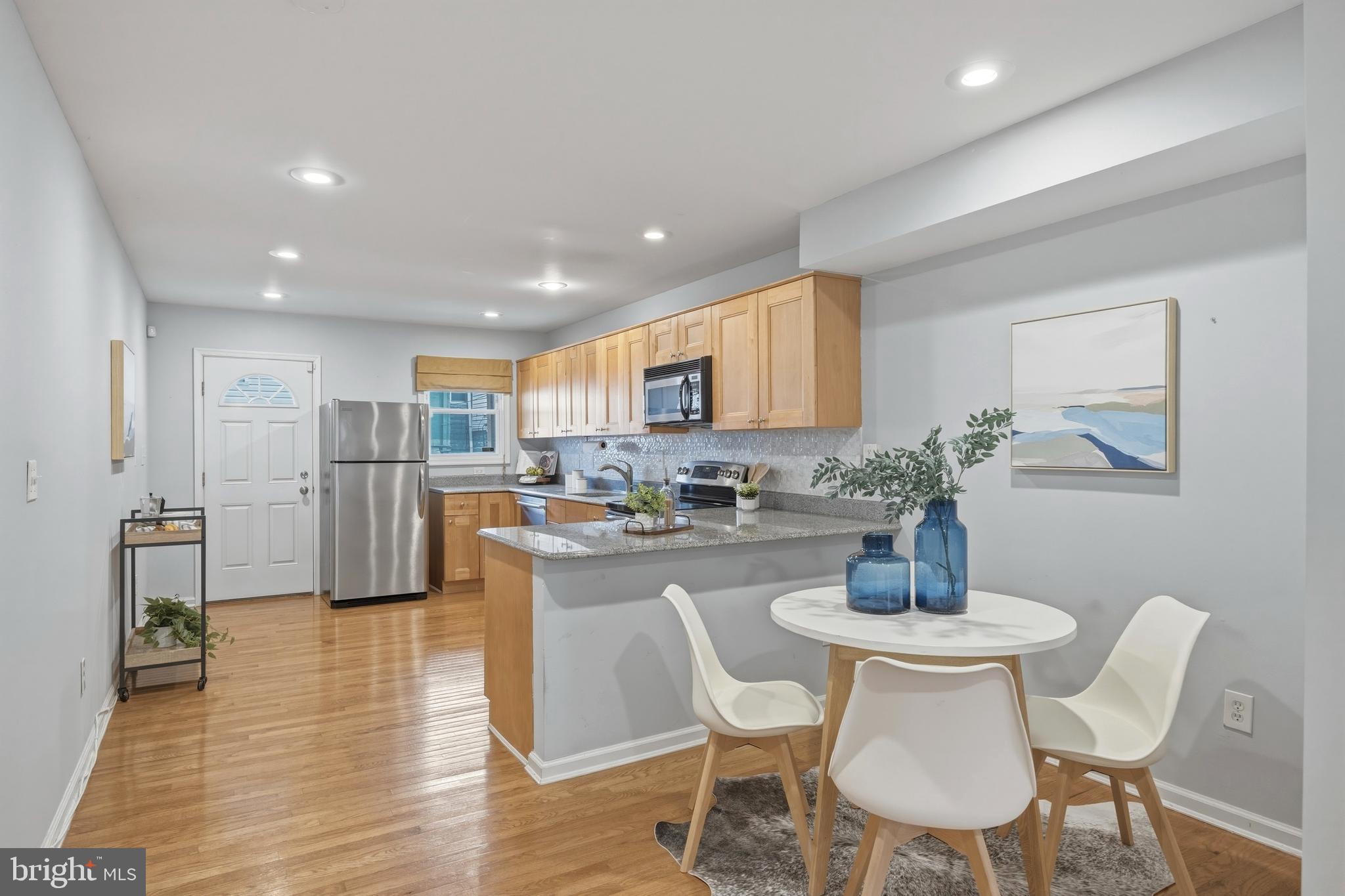 1419 Andre Street Baltimore, MD 21230 - Photo 5 of 25 a kitchen with stainless steel appliances kitchen island granite countertop a dining table chairs and granite counter tops