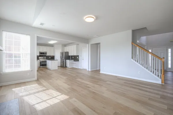 an empty room with windows and fireplace