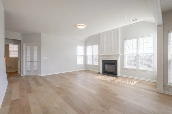 a view of an empty room with a window and fireplace