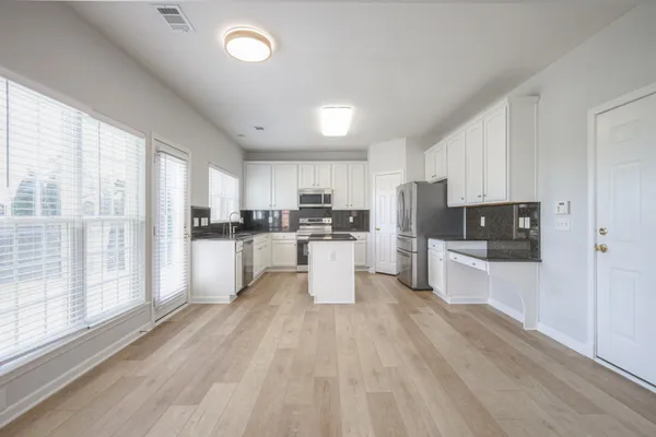 a kitchen with a refrigerator a sink a stove a microwave and cabinets
