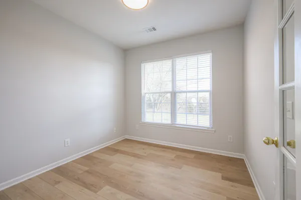 a view of a hallway with wooden floor and entryway