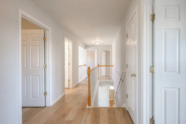 an empty room with chandelier fan and windows