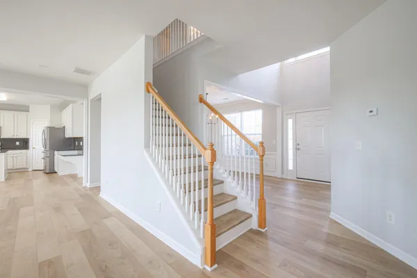 a view of a hallway with wooden floor and staircase