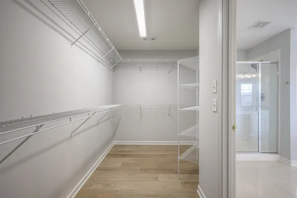 a view of an empty room and chandelier fan