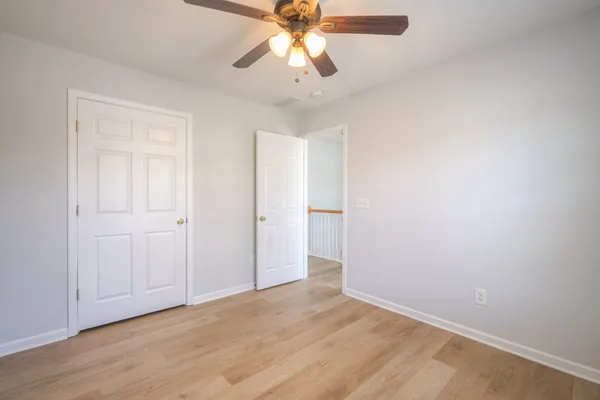 a view of room with wooden floor and ceiling fan
