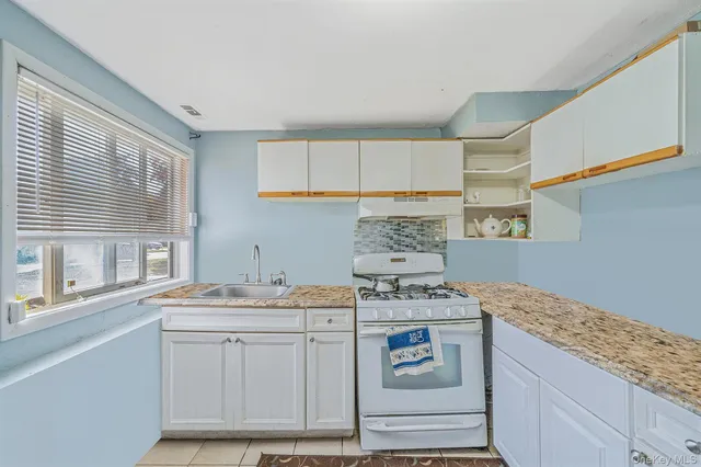a kitchen with stainless steel appliances granite countertop a sink stove and cabinets