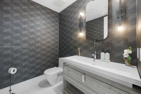 a bathroom with a sink a toilet and mirror