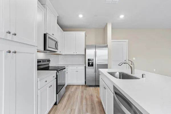 a kitchen with stainless steel appliances granite countertop a sink stove and refrigerator