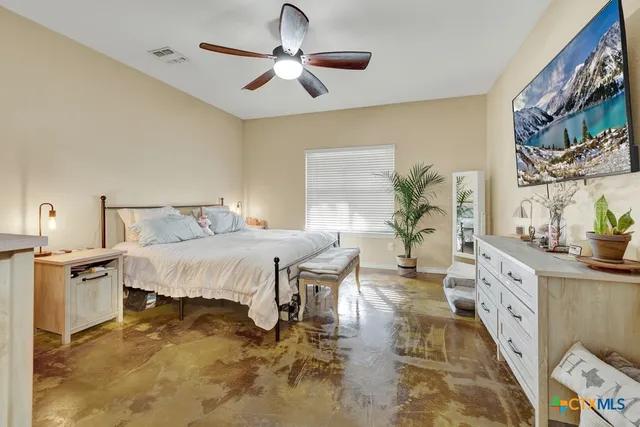 a spacious bedroom with a bed and a chandelier