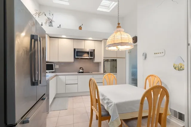 a kitchen with microwave a stove a table and chairs in it