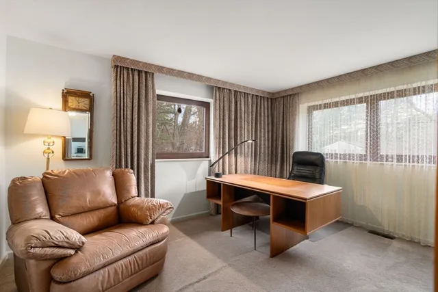 a living room with furniture a large window and a wooden floor