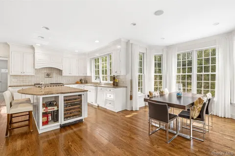 a kitchen with granite countertop a stove and white cabinets