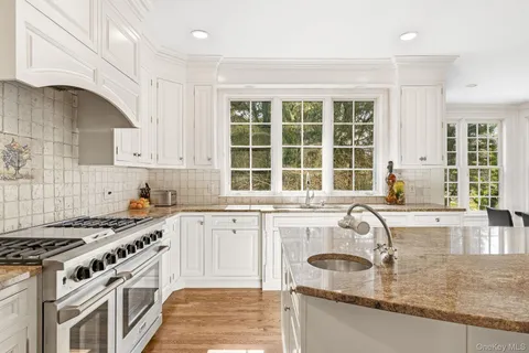 a kitchen with granite countertop a sink stove and cabinets