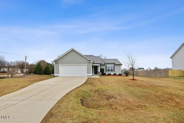 a view of an house with backyard and trees