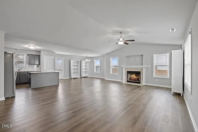 a view of an empty room with a fireplace and a window