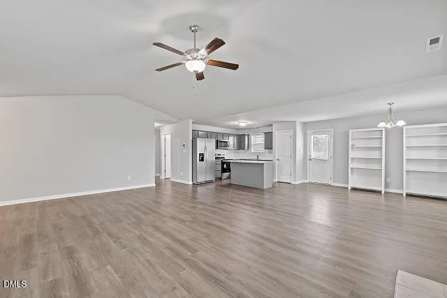 a view of empty room with wooden floor
