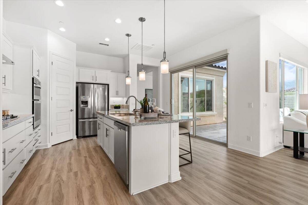 10 Gamay Rancho Mirage, CA 92270 - Photo 23 of 86 a kitchen with stainless steel appliances granite countertop a refrigerator a sink dishwasher a stove and white countertops with wooden floor