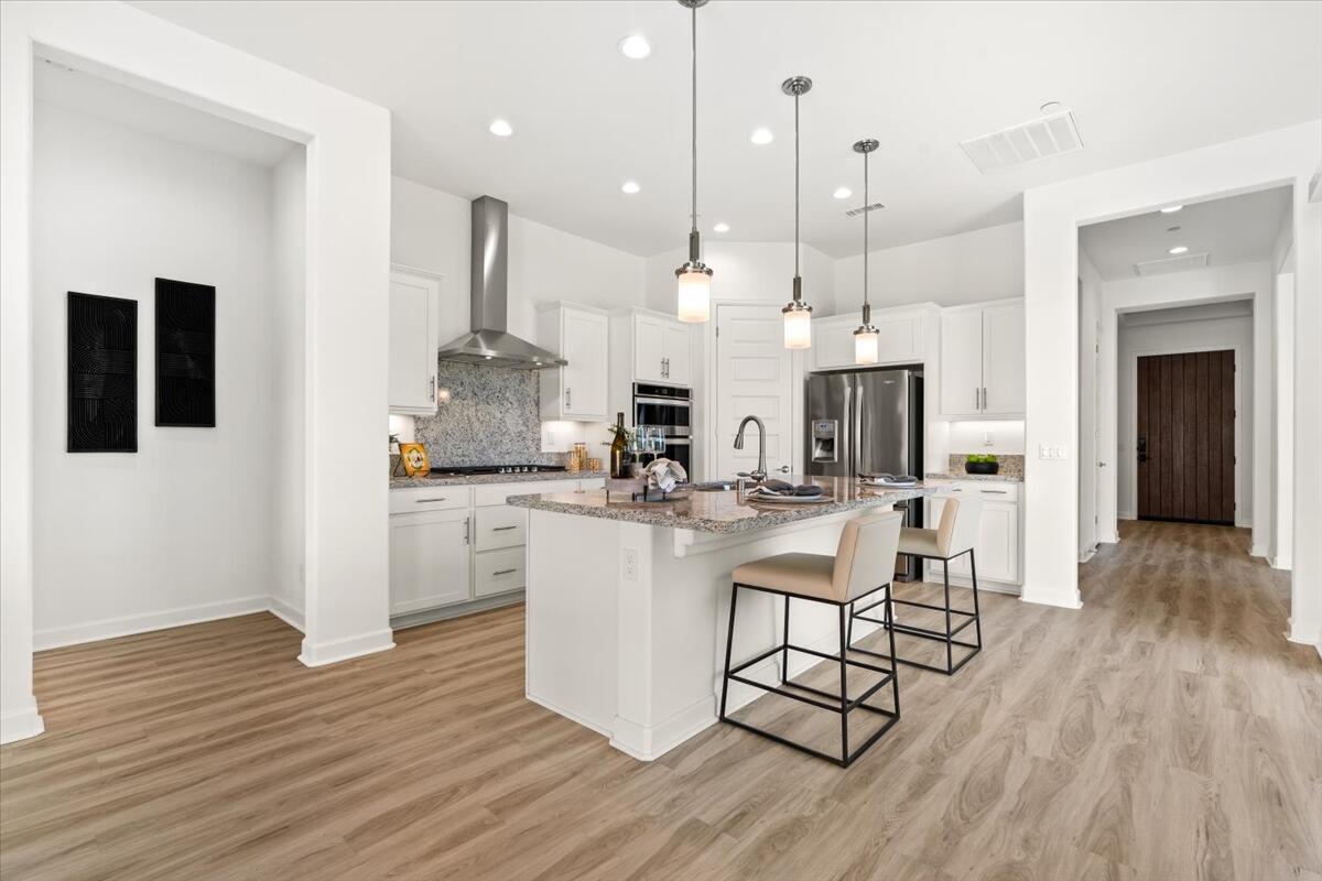 10 Gamay Rancho Mirage, CA 92270 - Photo 7 of 86 a kitchen with stainless steel appliances granite countertop a refrigerator a stove a sink dishwasher and a dining table with wooden floor