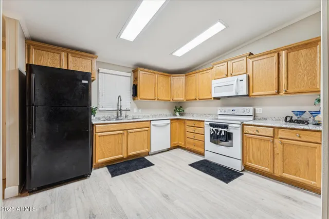 a kitchen with stainless steel appliances granite countertop a refrigerator and a stove top oven