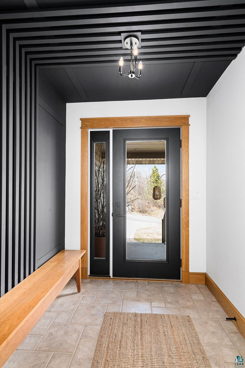 4856 Kingston Street Duluth, MN 55804 - Photo 2 of 88 Entryway featuring a black paneled ceiling with decorative trim, a contemporary semi-flush mount light fixture, and a vertical slat accent wall